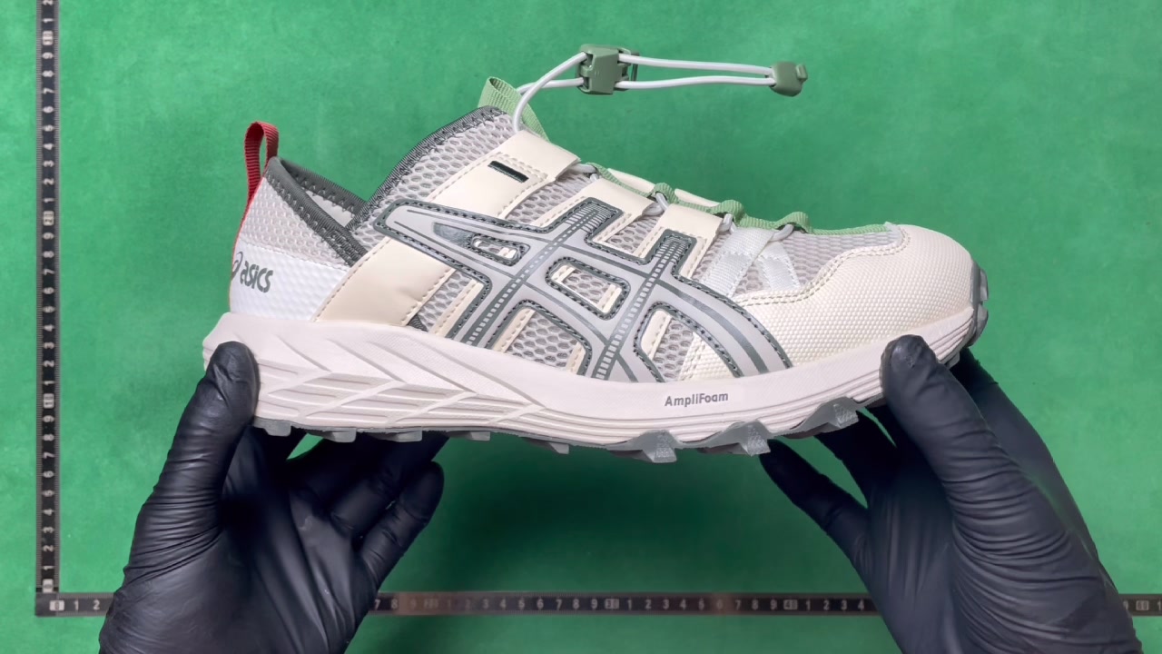 White and grey ASICS-marked trail-style shoe with pale green webbing